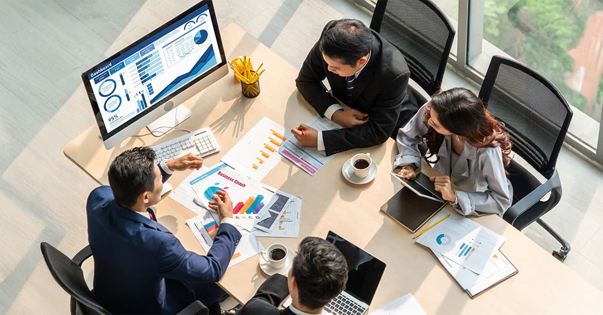 IT and business leaders reviewing a governance dashboard in a meeting room